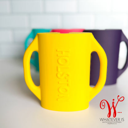 personalized yellow baby food pouch holders with easy-grip handles designed to prevent toddlers from squeezing yogurt and puree pouches and making a mess.